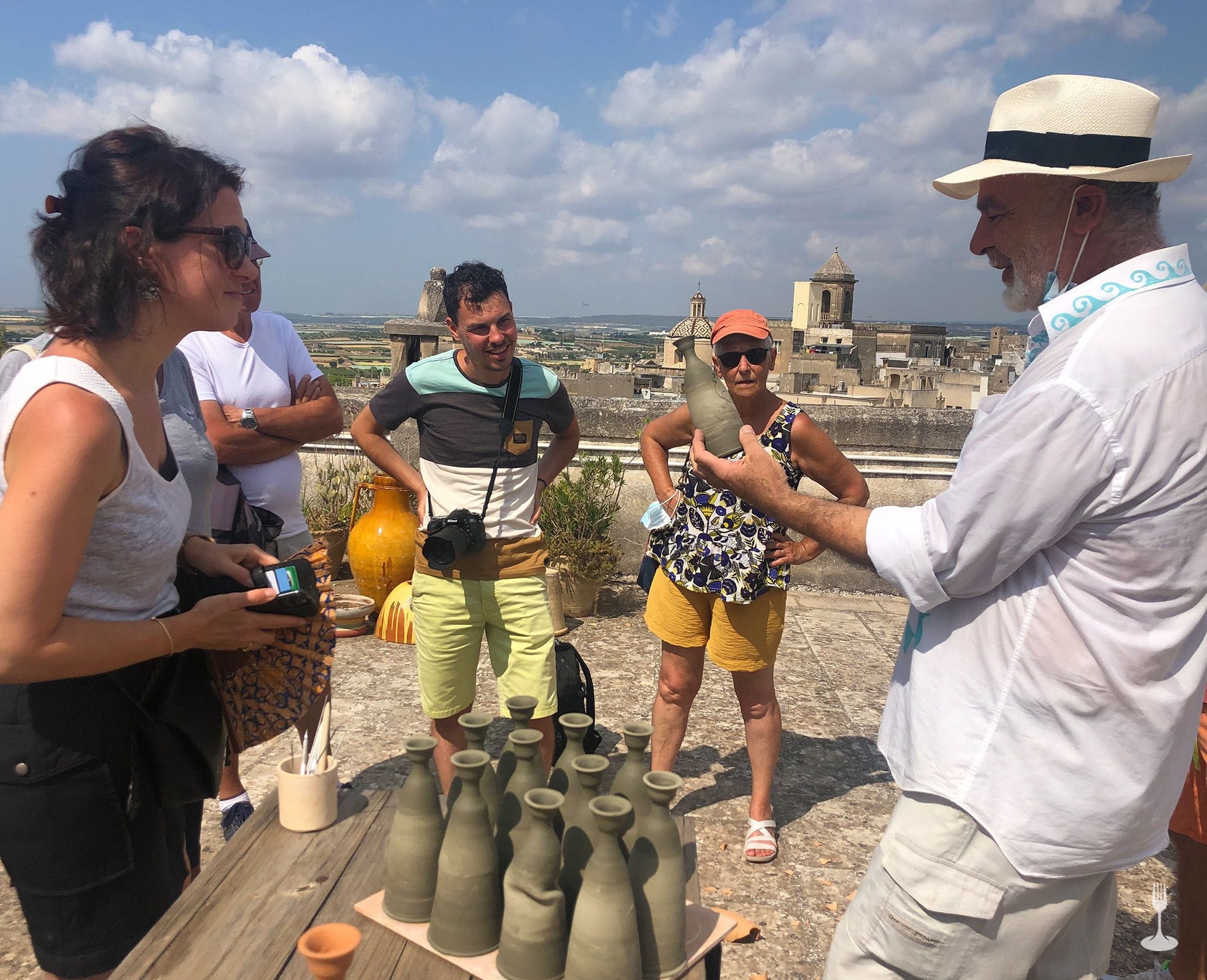 Discovering the treasures of the Ceramics District of Grottaglie Master ceramist decorating personalised terracotta vases on the terrace of the building