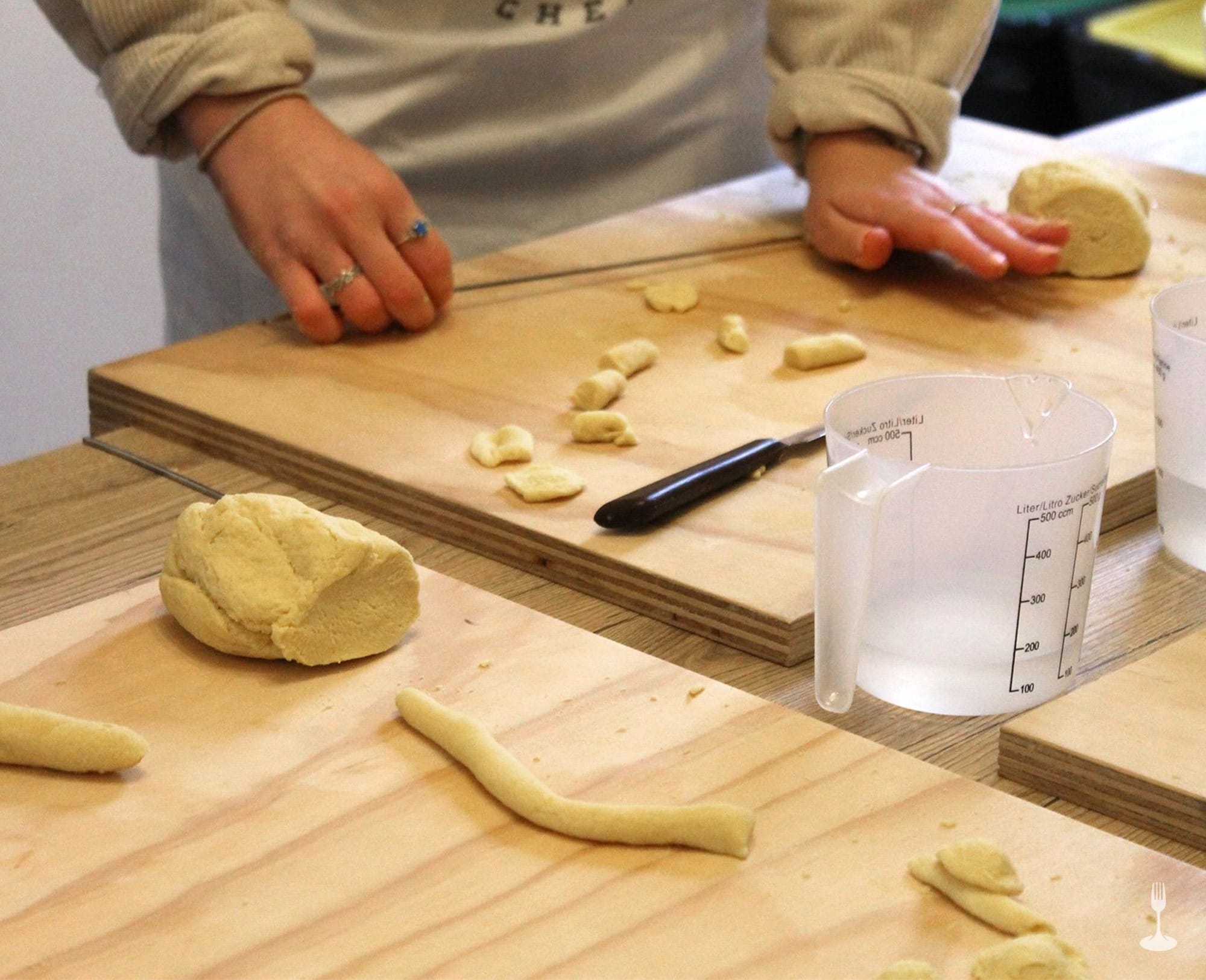 Mano stende le prime orecchiette fatte sulla spianatoia Mano stende le prime orecchiette fatte sulla spianatoia