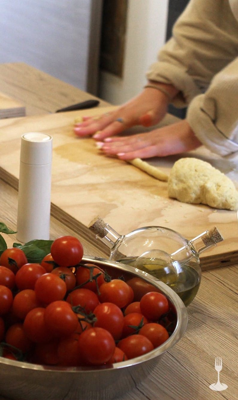 Ospiti lavorano nel creare forme di pasta accompagnati da un calice di vino bianco Ospiti lavorano nel creare forme di pasta accompagnati da un calice di vino bianco