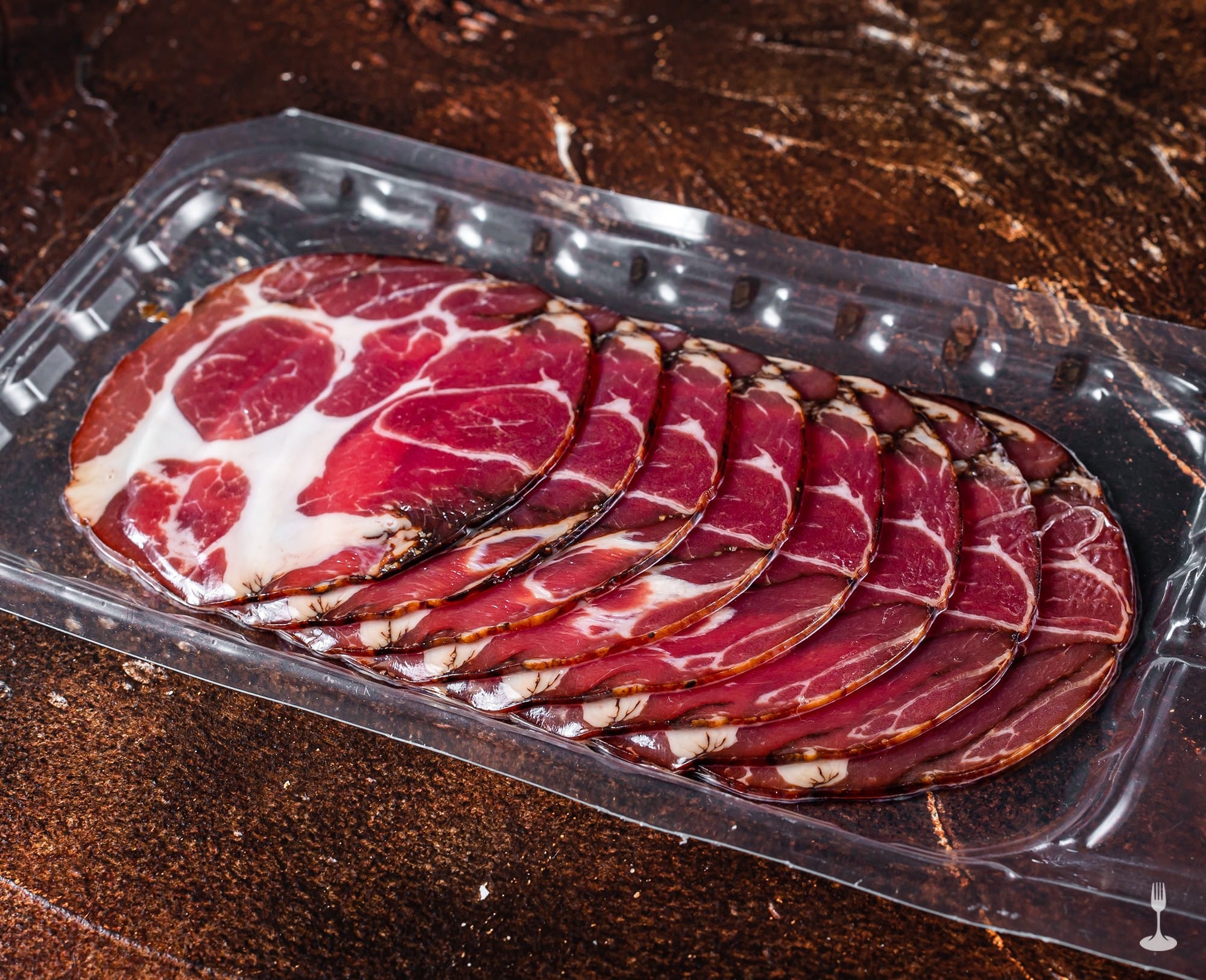 Capocollo di Martina Franca finemente affettato e disposto in una vaschetta di plastica Capocollo di Martina Franca finemente affettato e disposto in una vaschetta di plastica